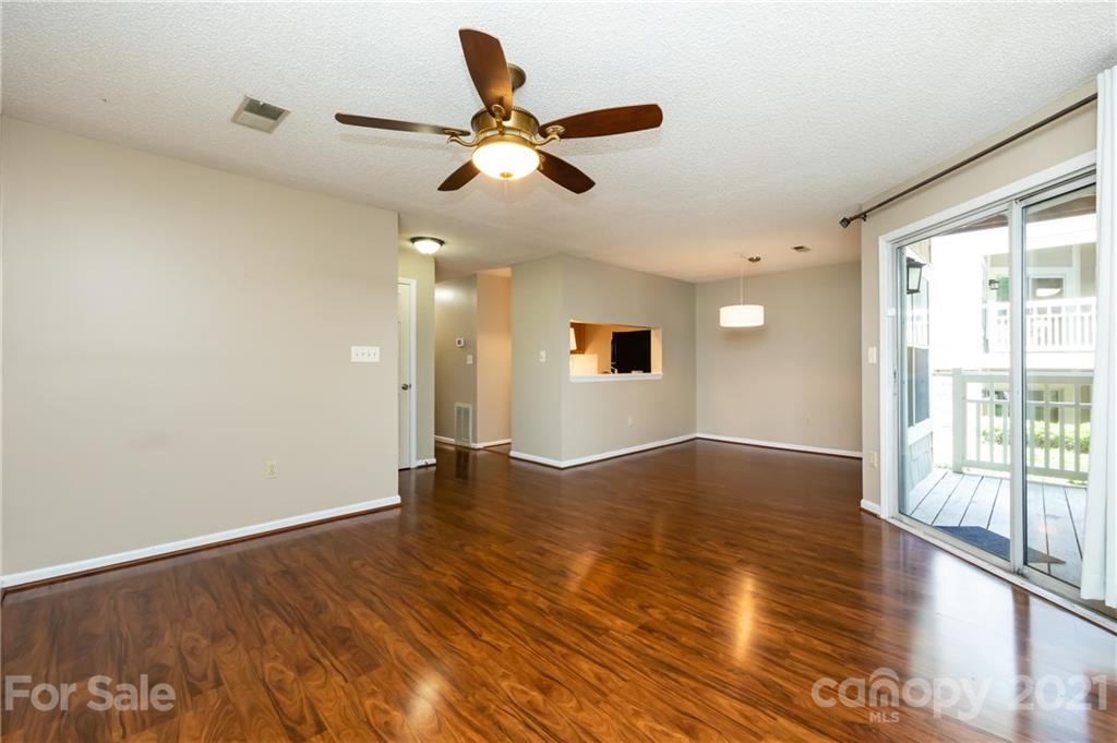 5003 Sharon Road, Unit G Charlotte, NC 28210 - Photo 8 of 42 a view of an empty room with wooden floor and a window