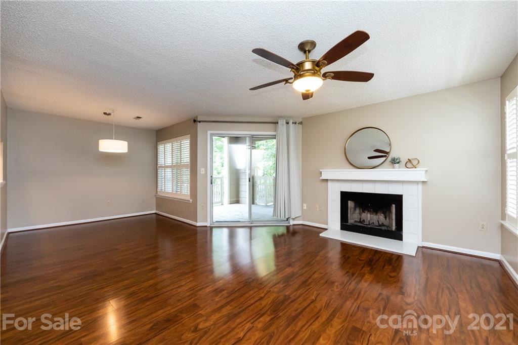 5003 Sharon Road, Unit G Charlotte, NC 28210 - Photo 9 of 42 a view of an empty room with wooden floor and a fireplace