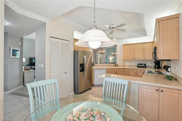 a kitchen with a refrigerator a sink and dishwasher with a dining table