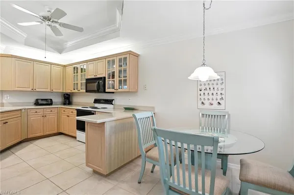 a kitchen with stainless steel appliances granite countertop a stove a sink dishwasher a dining table with chair and white cabinets