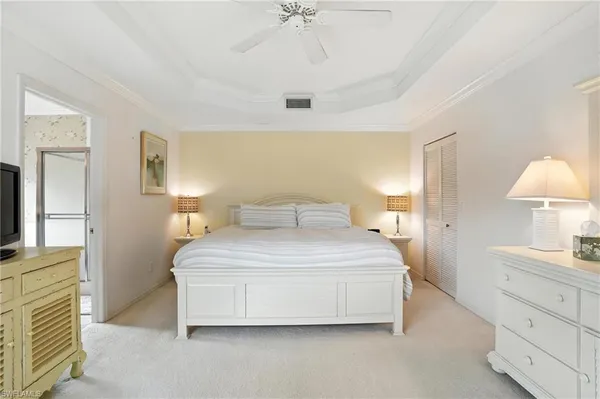 a spacious bedroom with a bed and a chandelier