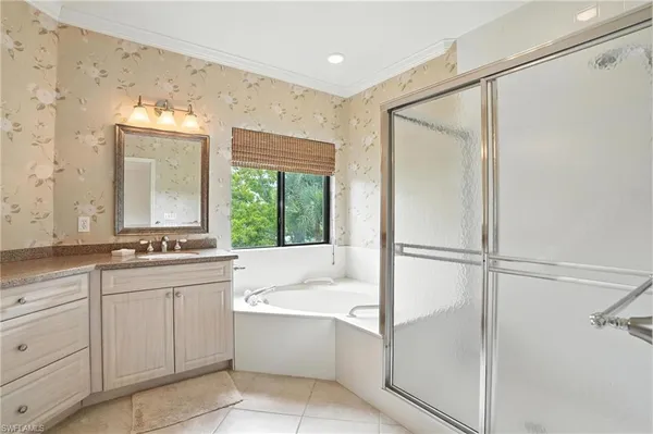 a bathroom with a tub sink shower and mirror