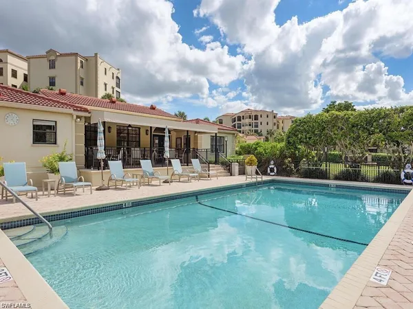 a view of house with swimming pool and chairs