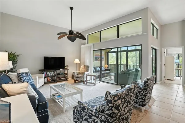a living room with furniture a flat screen tv and a large window