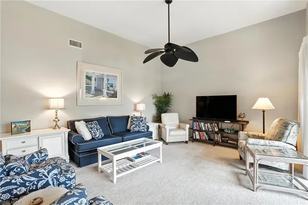 a living room with furniture a ceiling fan and a window