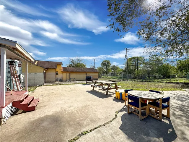 a view of a patio with dining table and chairs with a fire pit