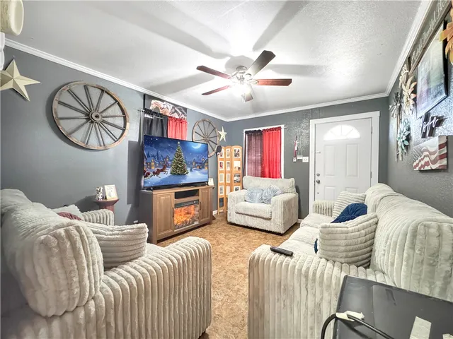 a living room with furniture a flat screen tv and a wall painting