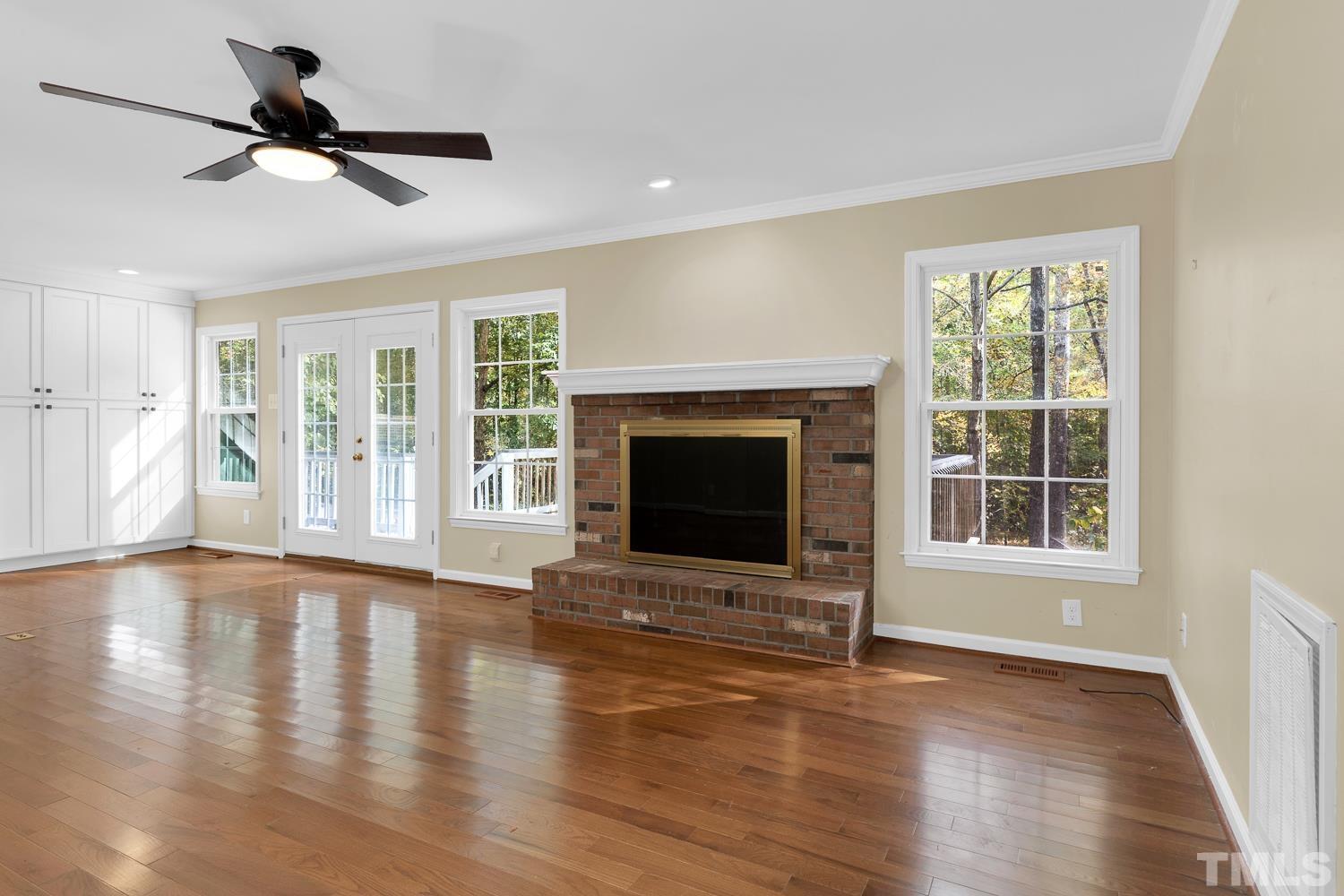 5908 Scalybark Road Durham, NC 27712 - Photo 14 of 30 a view of empty room with wooden floor and a fireplace