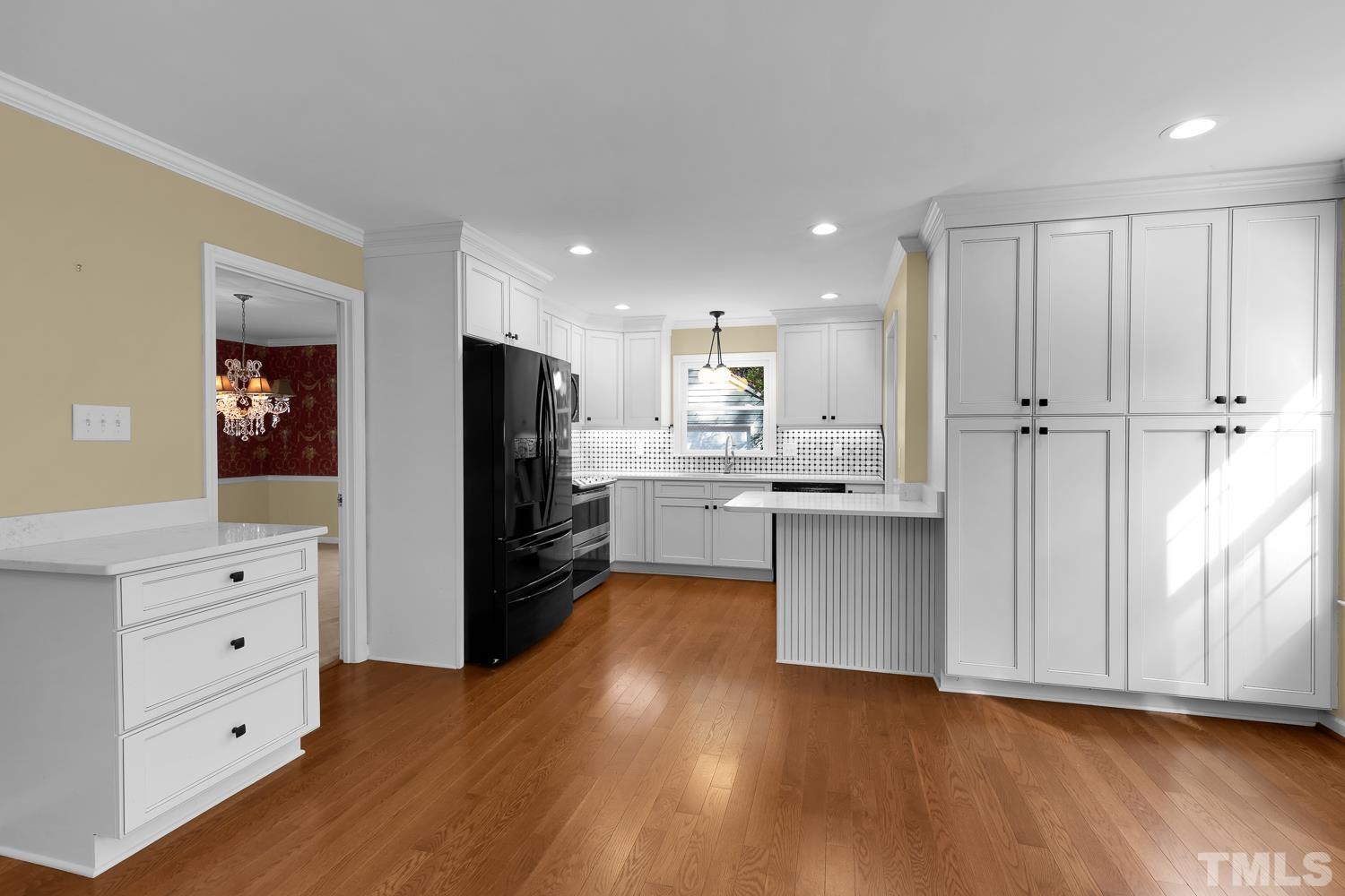 5908 Scalybark Road Durham, NC 27712 - Photo 16 of 30 a kitchen with a refrigerator and white cabinets