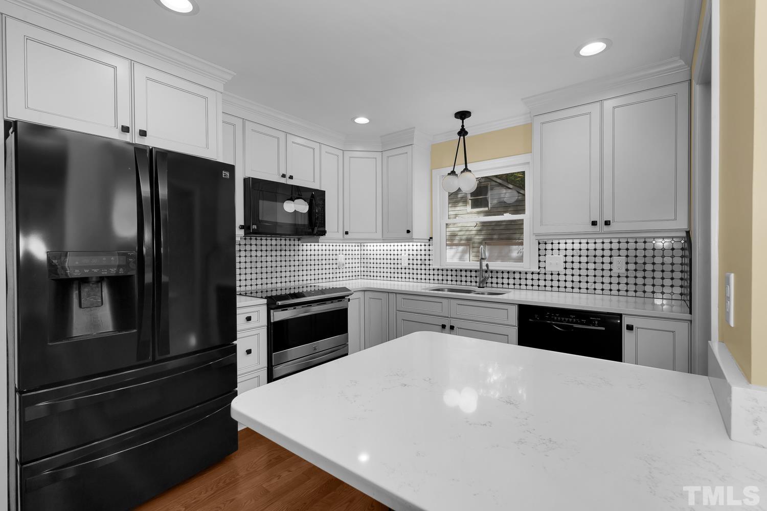 5908 Scalybark Road Durham, NC 27712 - Photo 17 of 30 a kitchen with stainless steel appliances a refrigerator sink and cabinets