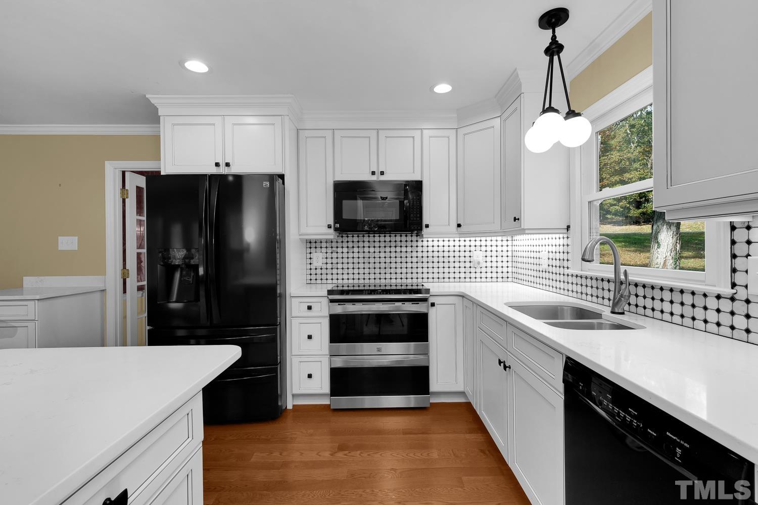 5908 Scalybark Road Durham, NC 27712 - Photo 18 of 30 a kitchen with a sink a refrigerator and a stove top oven