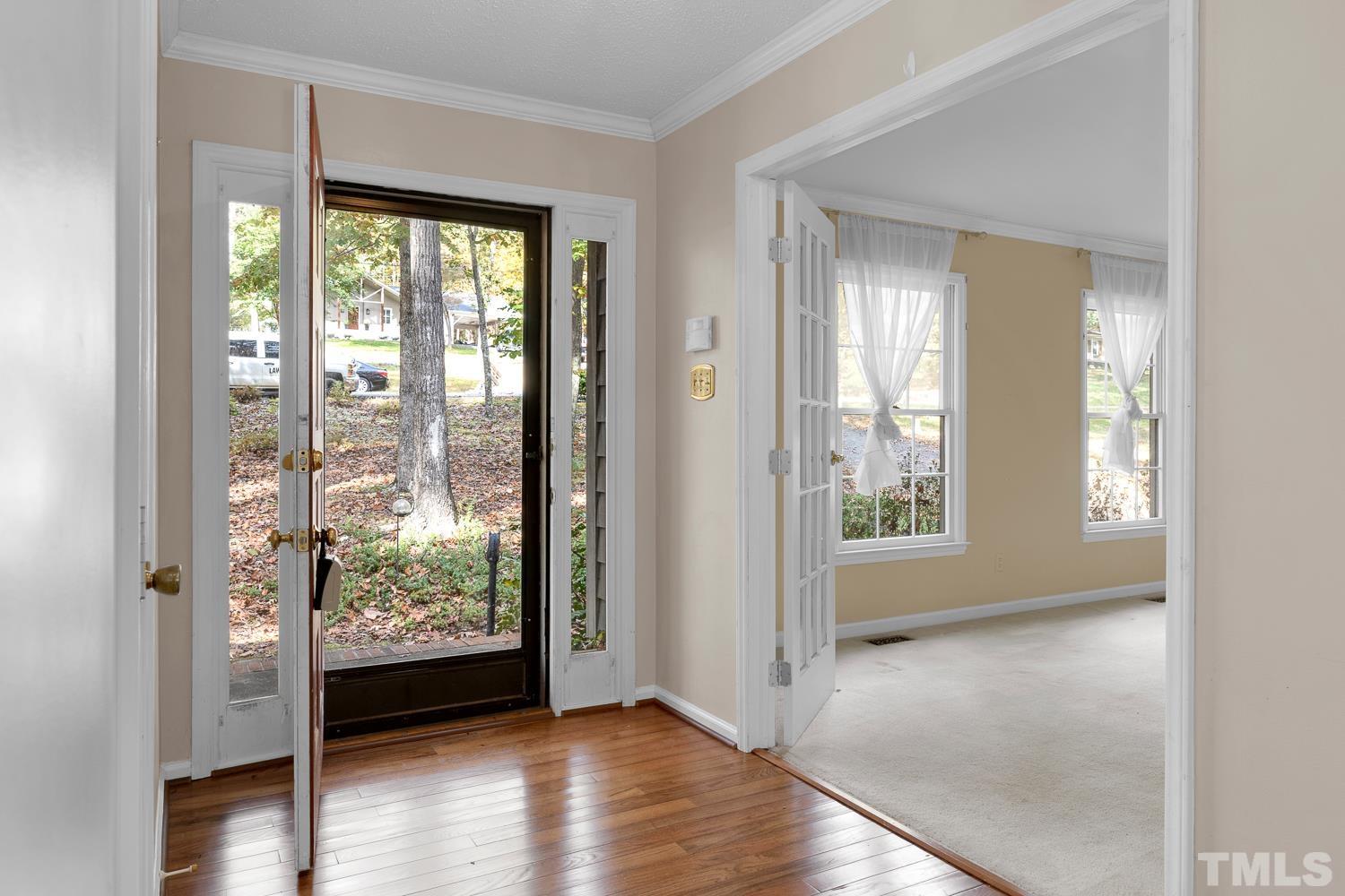 5908 Scalybark Road Durham, NC 27712 - Photo 3 of 30 a view of an entryway with wooden floor and a livingroom