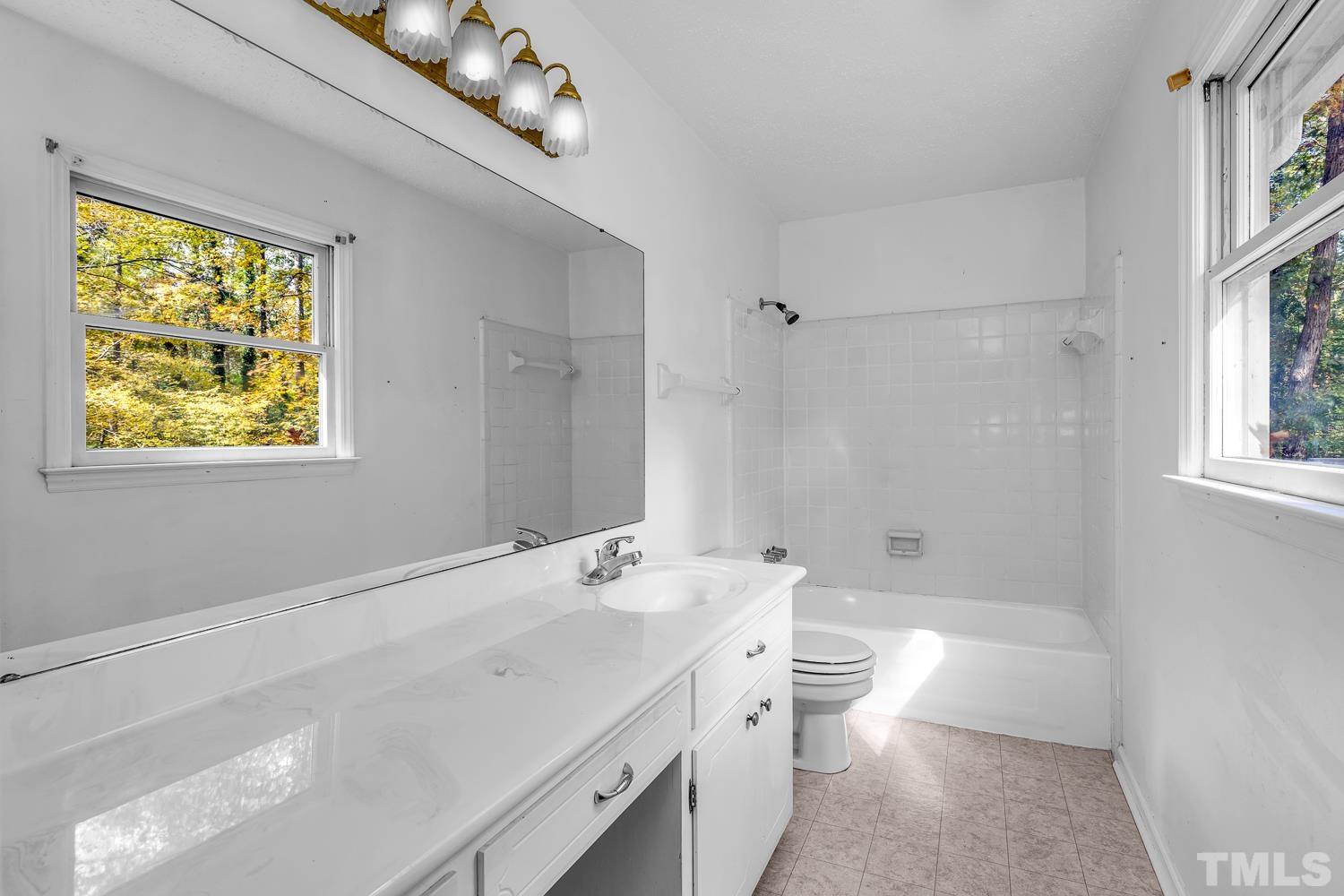5908 Scalybark Road Durham, NC 27712 - Photo 24 of 30 a bathroom with a double vanity sink toilet and shower