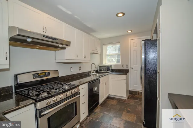 a kitchen with stainless steel appliances a stove a sink and a refrigerator