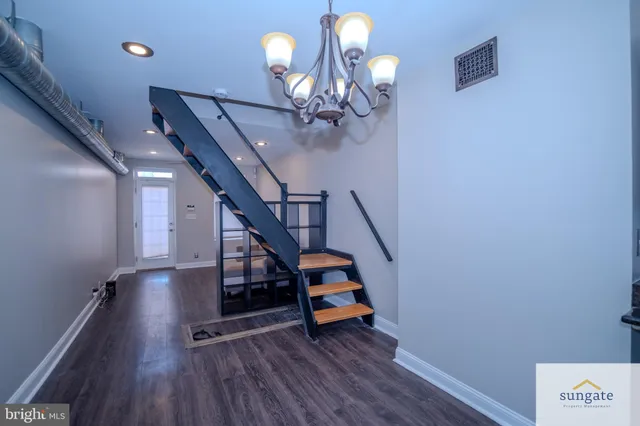 a view of a hallway with wooden floor and staircase