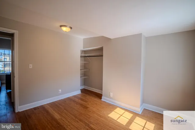 a view of empty room with wooden floor