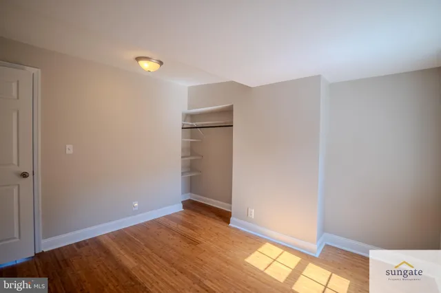 a view of empty room with wooden floor