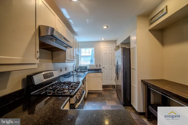 a kitchen with a refrigerator and a stove top oven
