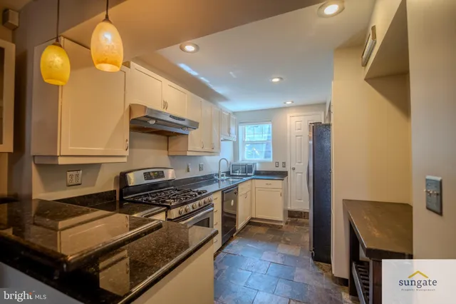 a kitchen with stainless steel appliances a stove a sink and a refrigerator