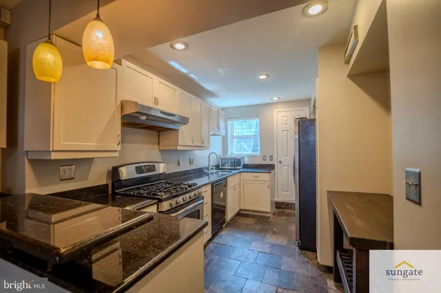 a kitchen with stainless steel appliances a stove a sink and a refrigerator