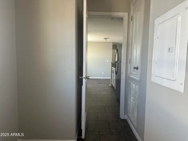 a view of a hallway with a chandelier fan and windows