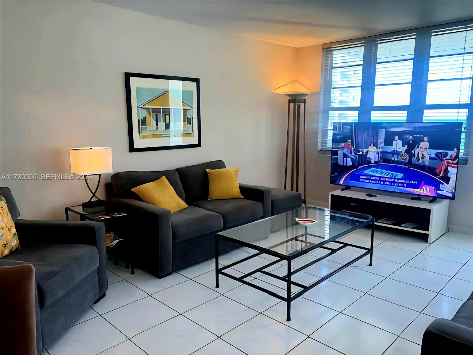 a living room with furniture and a floor to ceiling window