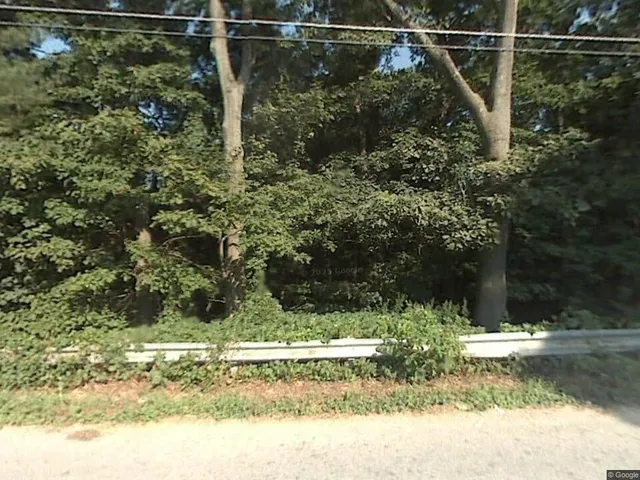 a view of a yard with wooden fence