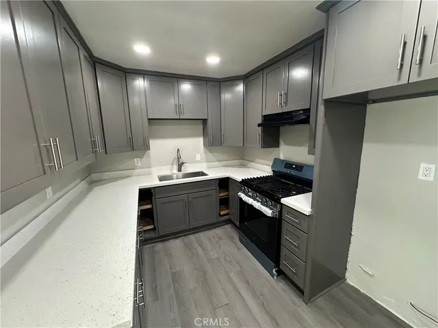 a kitchen with stainless steel appliances granite countertop a sink a stove and a refrigerator