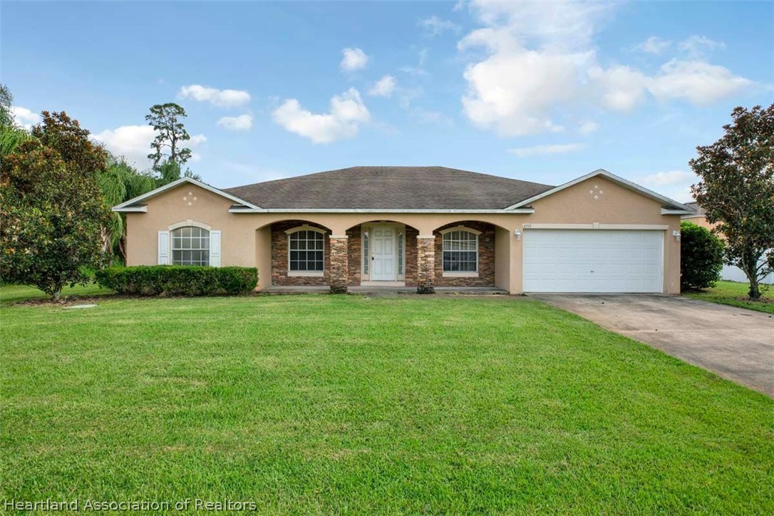 4755 Tarrega Street Sebring, FL 33872 - Photo 1 of 35 a front view of a house with a garden
