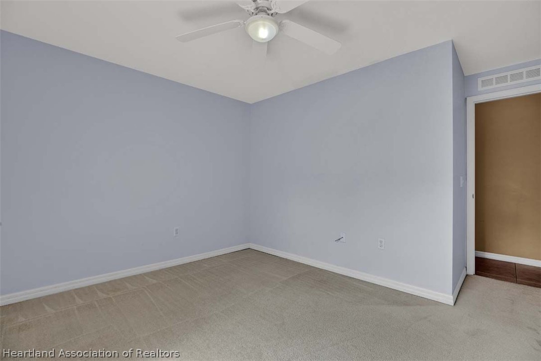 4755 Tarrega Street Sebring, FL 33872 - Photo 14 of 35 an empty room with a ceiling fan and carpet