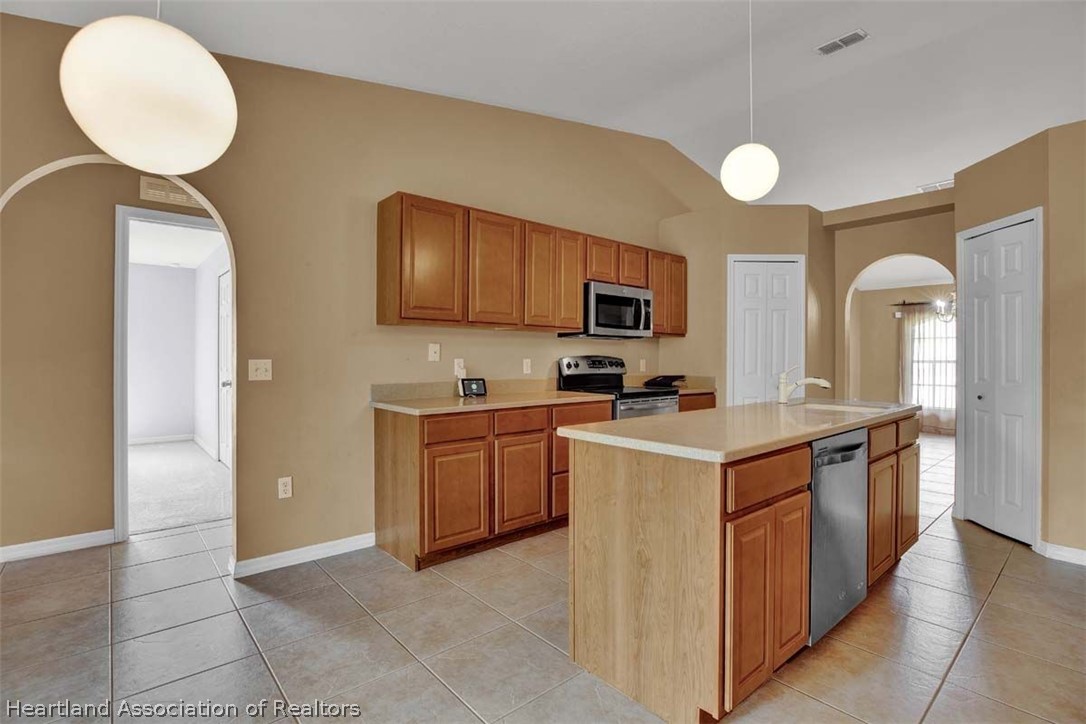 4755 Tarrega Street Sebring, FL 33872 - Photo 18 of 35 a kitchen with stainless steel appliances a stove refrigerator sink and microwave