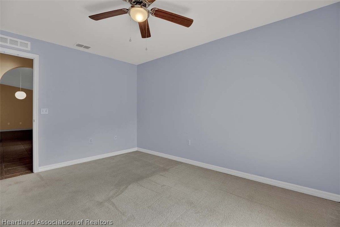 4755 Tarrega Street Sebring, FL 33872 - Photo 21 of 35 an empty room with a ceiling fan and carpet