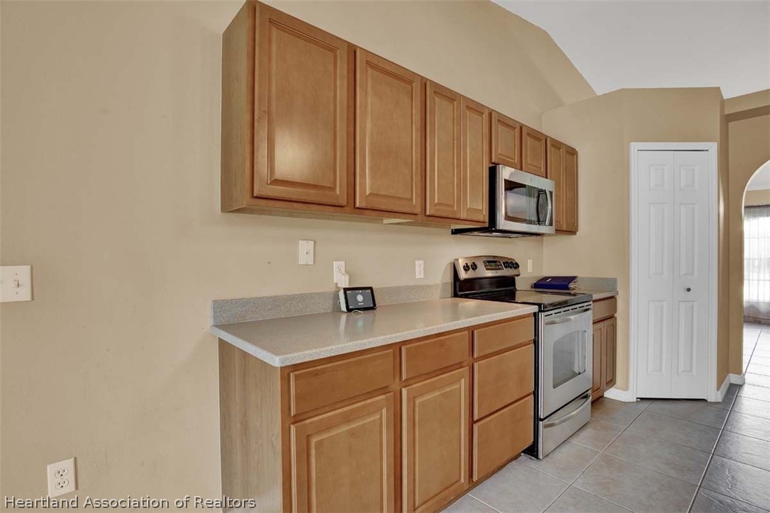 4755 Tarrega Street Sebring, FL 33872 - Photo 24 of 35 a kitchen with stainless steel appliances granite countertop a sink stove and microwave