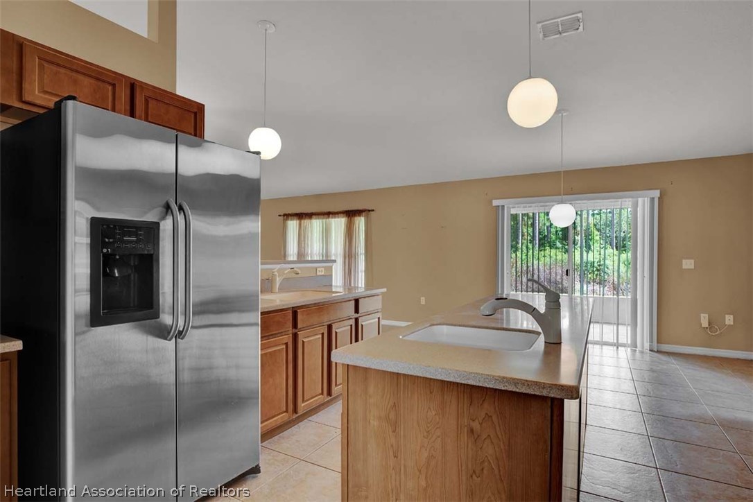 4755 Tarrega Street Sebring, FL 33872 - Photo 28 of 35 a kitchen with stainless steel appliances granite countertop a sink and a refrigerator