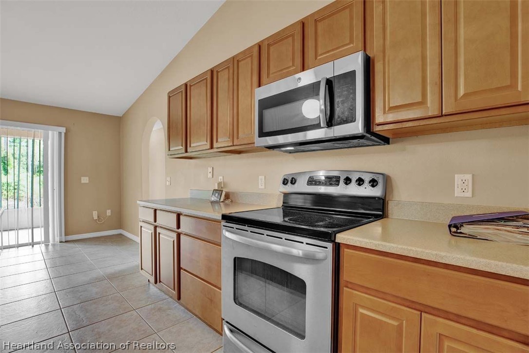 4755 Tarrega Street Sebring, FL 33872 - Photo 5 of 35 a kitchen with granite countertop a stove top oven microwave and cabinets