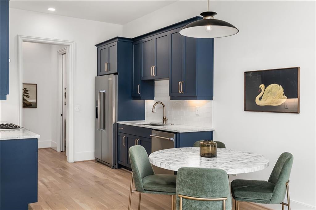 699 Eustace Street Southeast Atlanta, GA 30315 - Photo 12 of 53 a kitchen with stainless steel appliances granite countertop a table chairs and a refrigerator