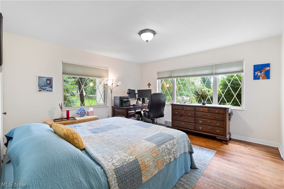443 Merriman Road Akron, OH 44303 - Photo 23 of 44 Bright interior space featuring expansive windows with diamond-patterned muntins, white trim, wood-finish flooring, and a flush-mount ceiling light fixture