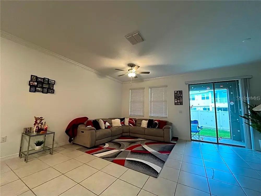 31751 Blue Passing Loop Wesley Chapel, FL 33545 - Photo 6 of 18 a living room with furniture gym equipment and a chandelier