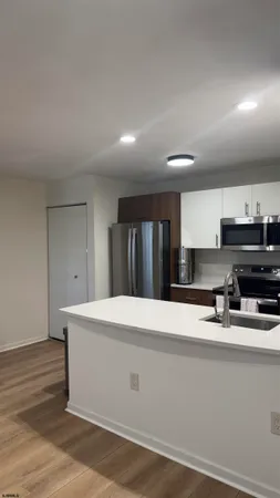a kitchen with kitchen island sink and refrigerator