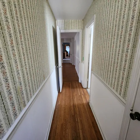 a view of a hallway with wooden floor and staircase
