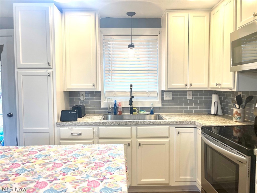 146 Home Street Rittman, OH 44270 - Photo 5 of 25 Kitchen featuring stainless steel appliances, sink, and hanging light fixtures