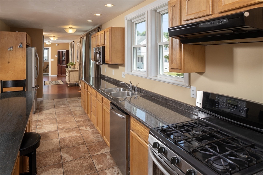 67 Newport Road Hull, MA 02045 - Photo 9 of 26 a kitchen with stainless steel appliances granite countertop a stove and a sink