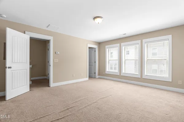an empty room with windows and closet