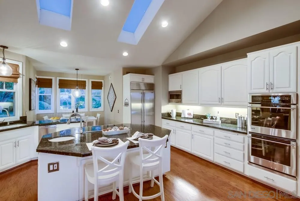 16157 Country Day Road Poway, CA 92064 - Photo 36 of 70 a kitchen with stainless steel appliances granite countertop a stove top oven a sink dishwasher and white cabinets with wooden floor
