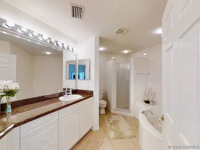a spacious bathroom with a granite countertop tub sink and mirror