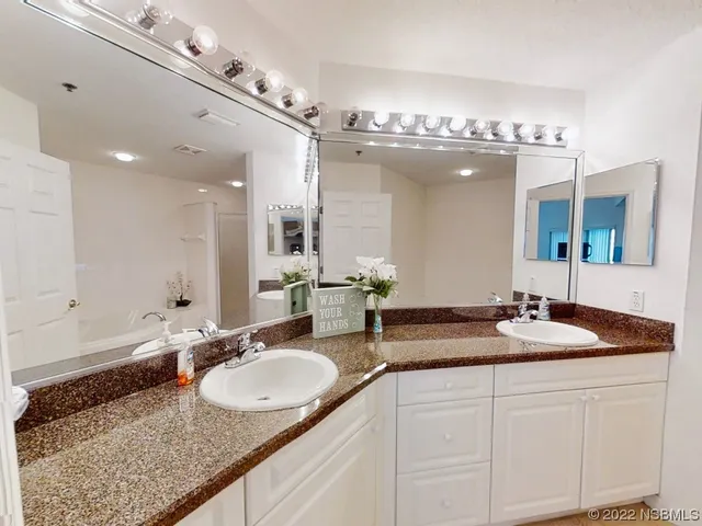 a bathroom with double sink and a mirror