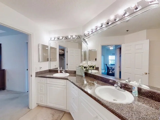 a spacious bathroom with a granite countertop double sink and a mirror