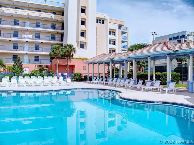 a view of a swimming pool with outdoor seating and a potted plant