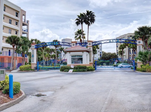 a front view of a building with palm trees