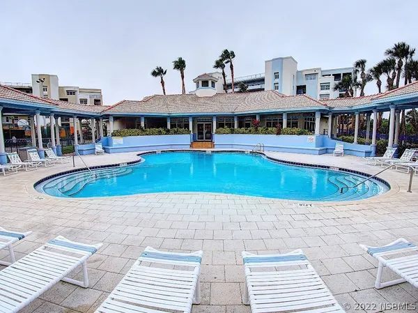 a view of a house with pool and sitting area